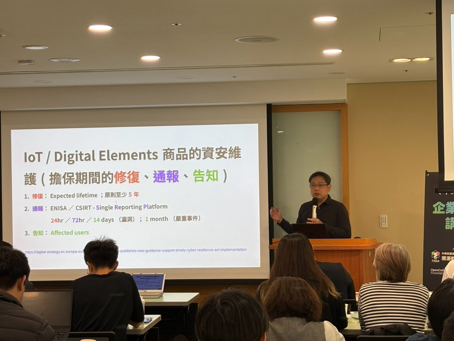 Lucien Lin 林誠夏在講臺上說明數位產品的資安維護，投影片列出修復、通報與告知